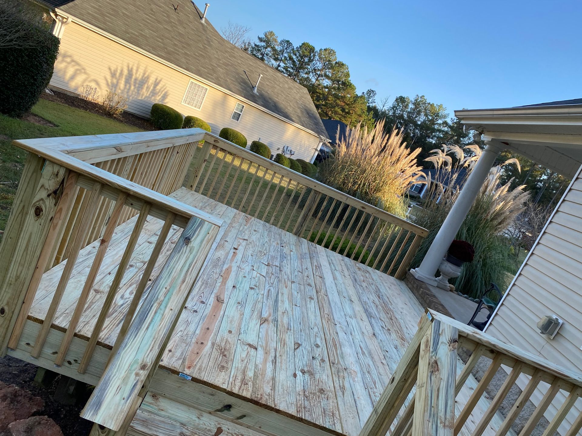 A wooden deck with stairs and a white railing.