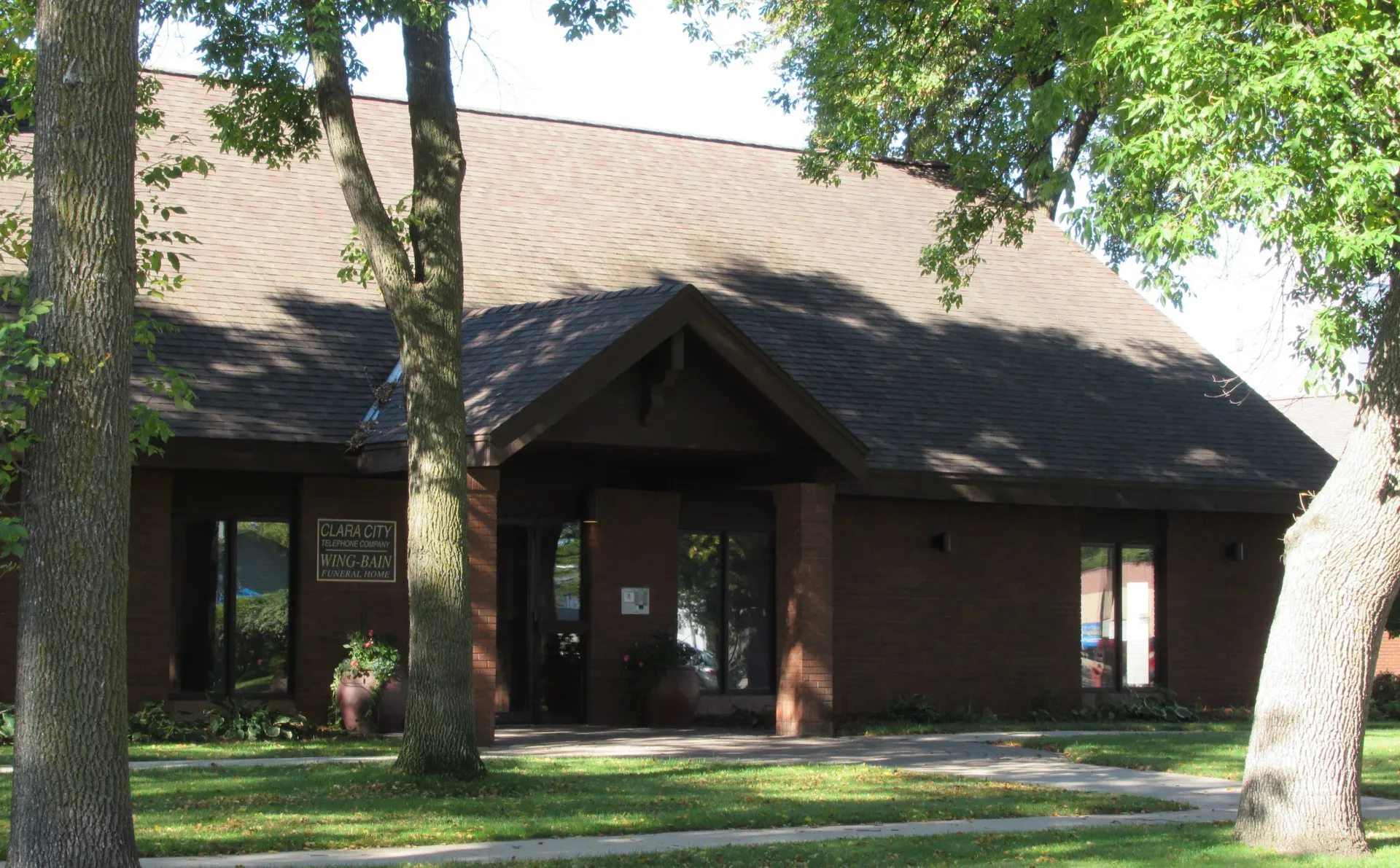 A brick building with a brown roof and a sign on the front that says ' grace '