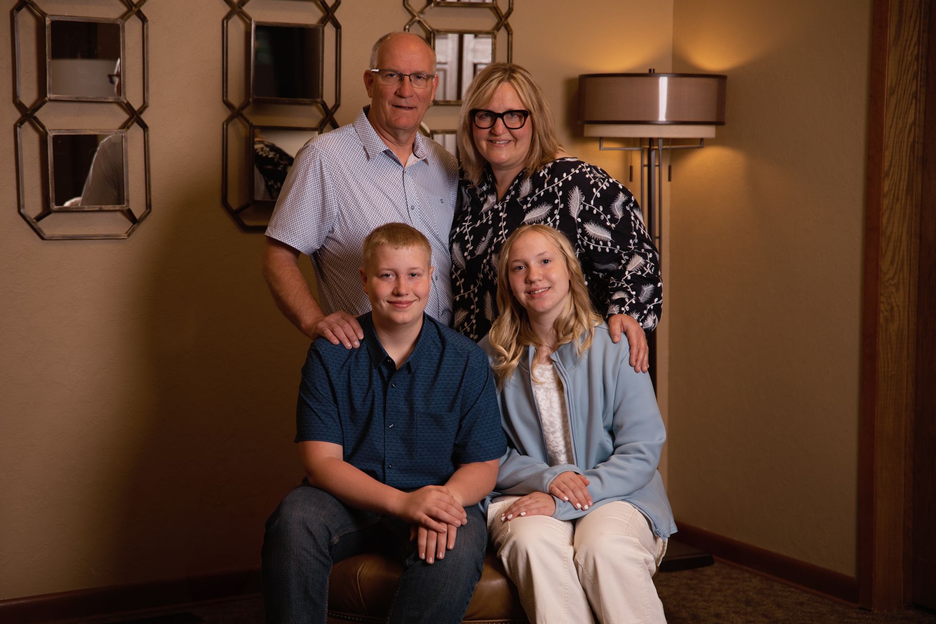 A family is posing for a picture in a living room.