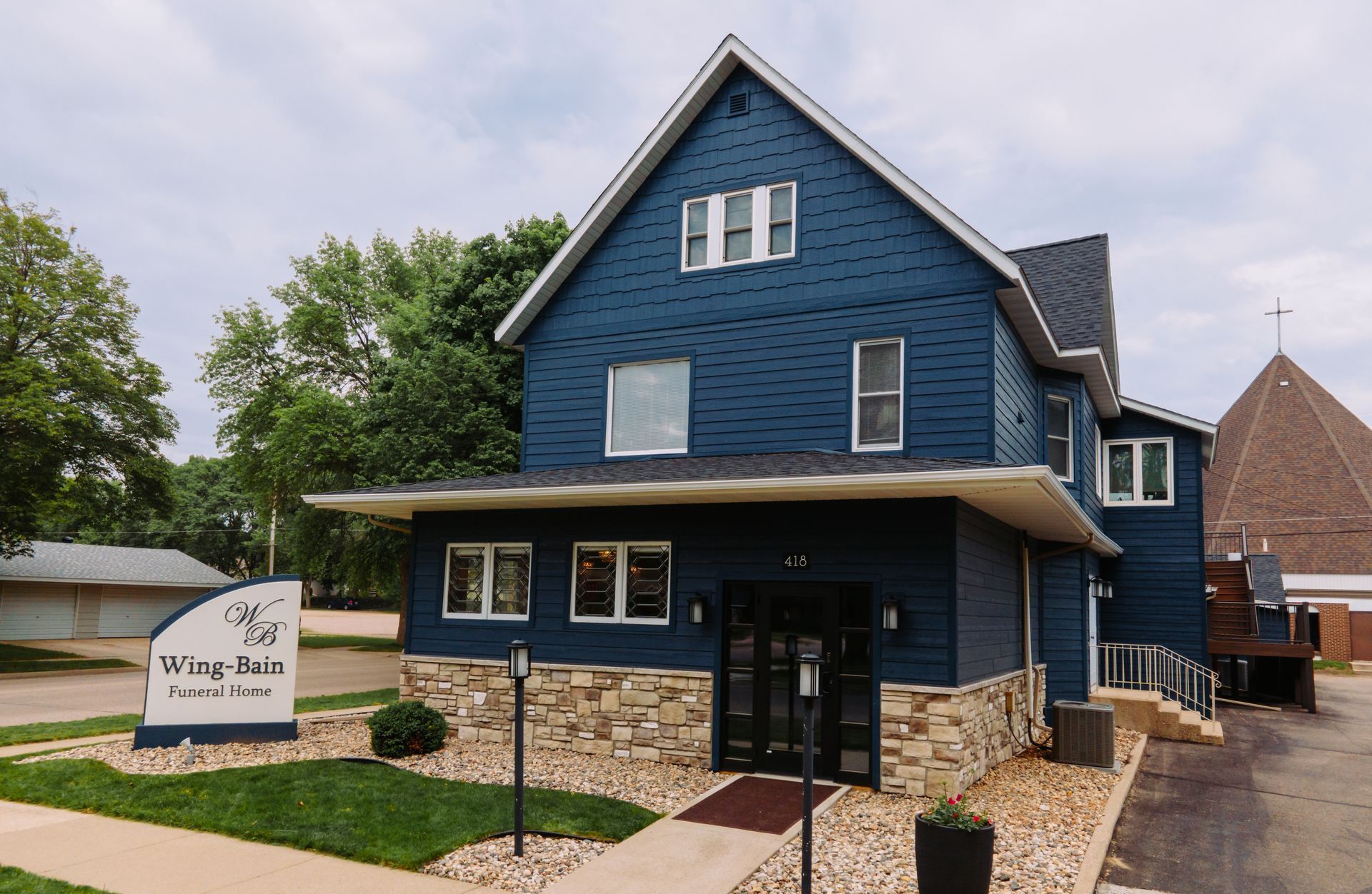 A blue house with a sign in front of it that says ' wisconsin funeral home '