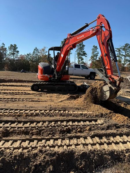 An excavator is digging a hole in the dirt on a construction site.
