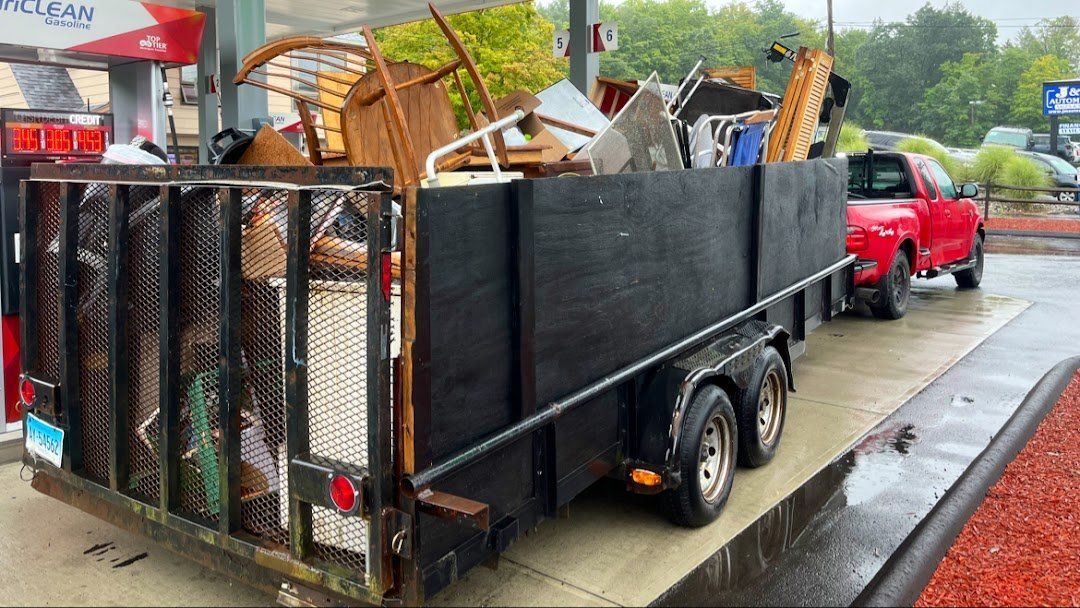 A pile of trash is sitting on the ground in front of a house.