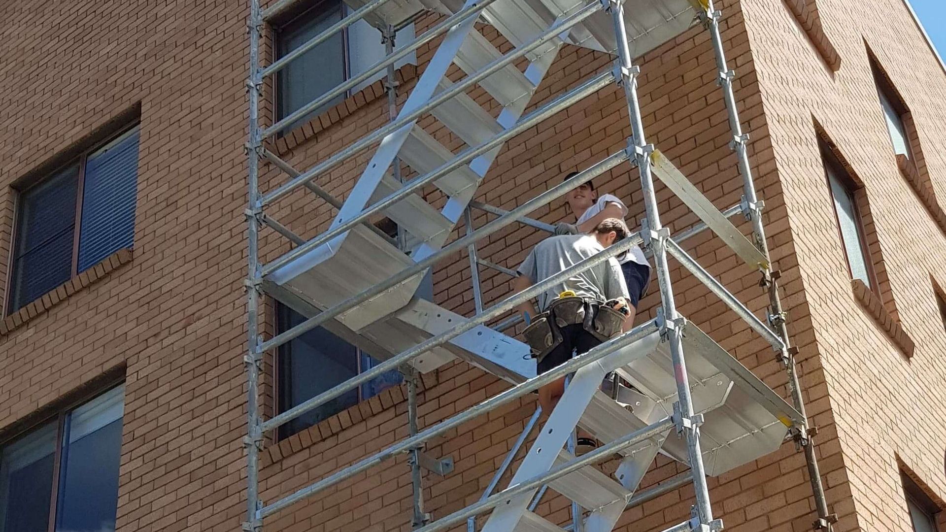 Safe stair access scaffolding on a multi-story brick building