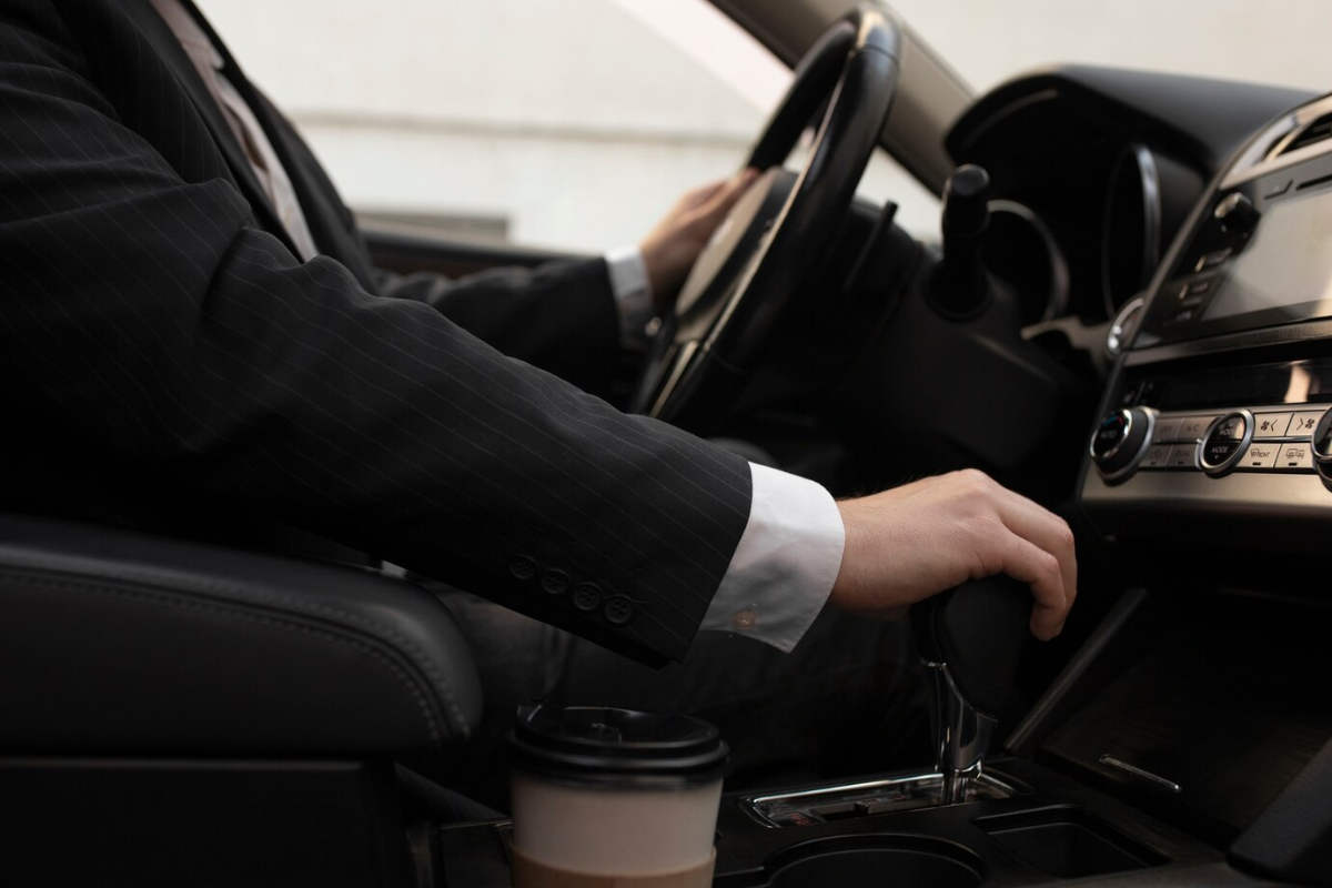 Professional driver seated in the driver’s seat of a luxury car