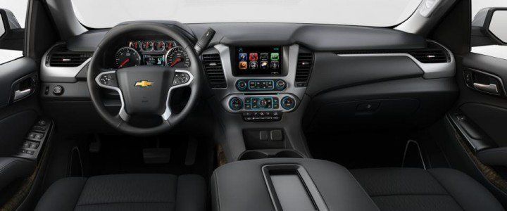 The interior of a chevrolet suburban with a steering wheel and dashboard.