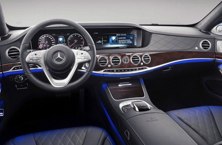 The interior of a mercedes benz s class with blue seats and a steering wheel.