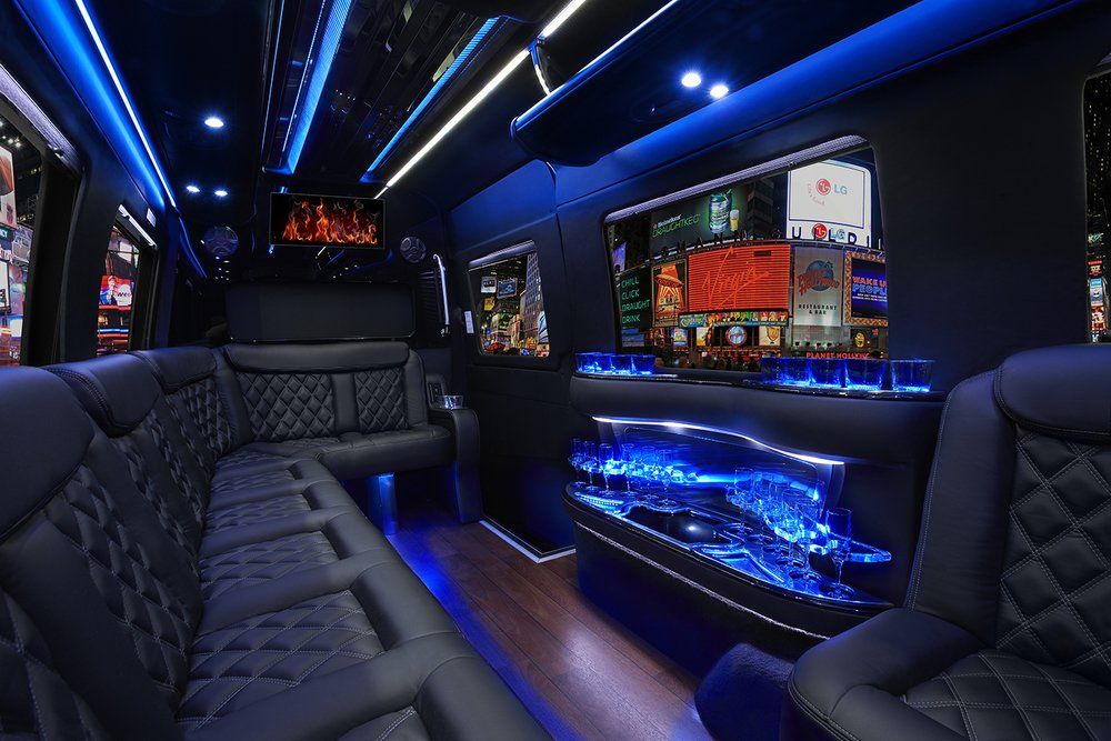 The inside of a limousine with a couch and a television.