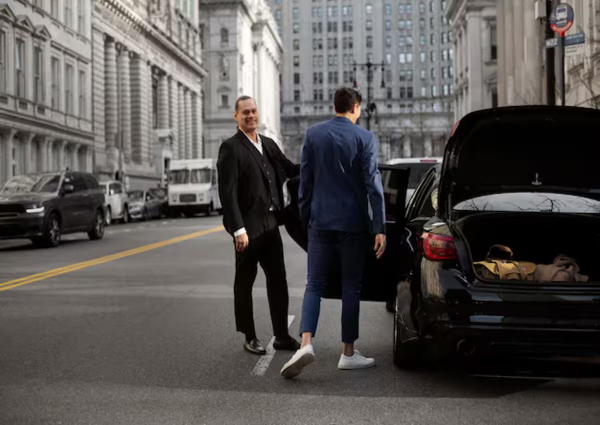 A businessman getting into a luxury car service 