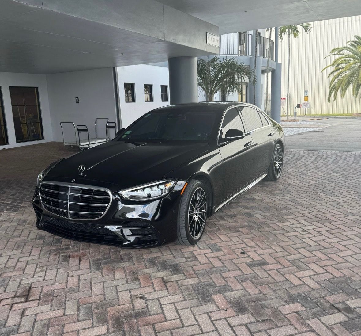 A black mercedes benz s class is parked in front of a building.