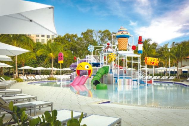 A swimming pool with a water park in the background