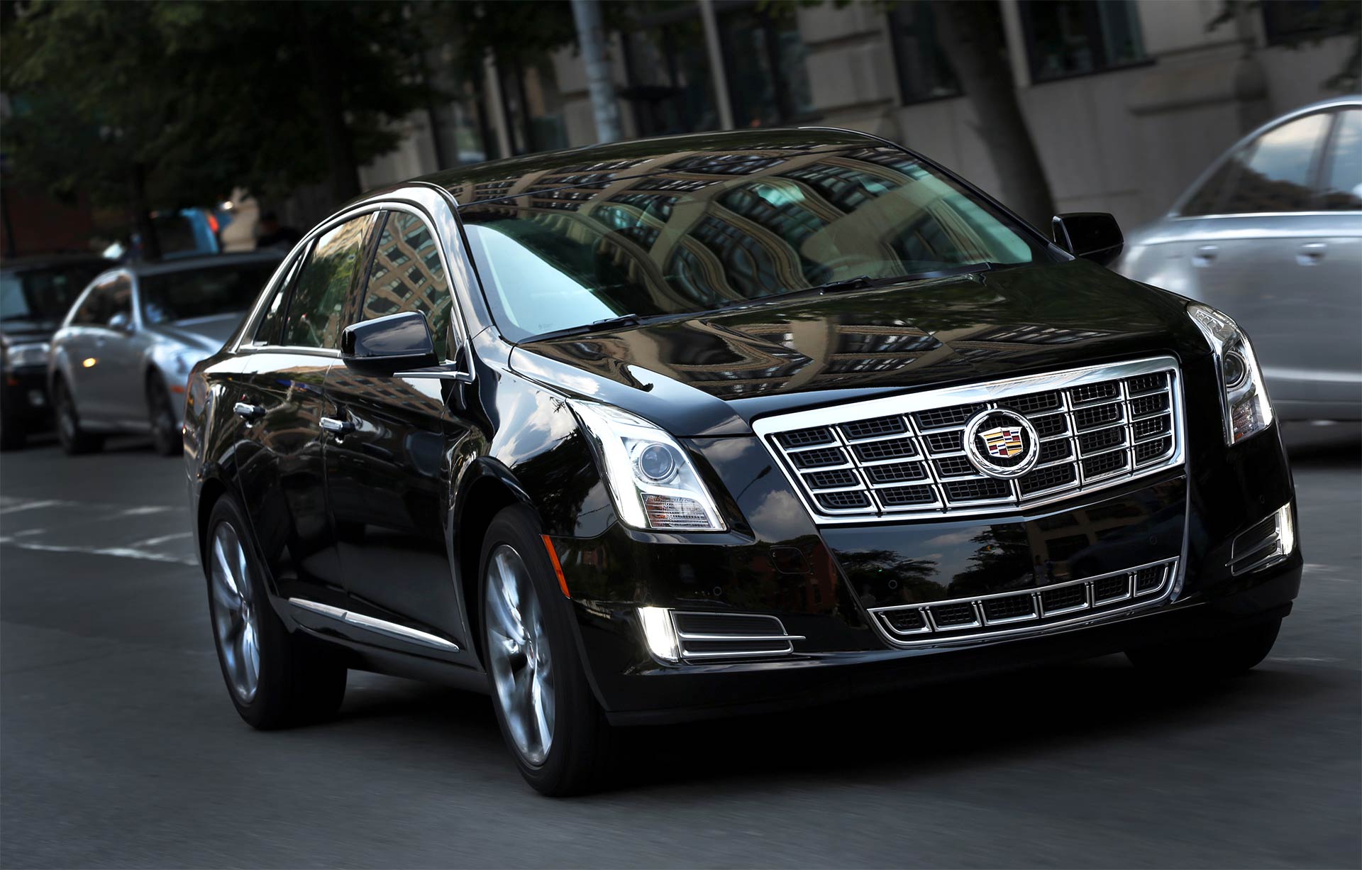 A black cadillac is parked on the side of the road