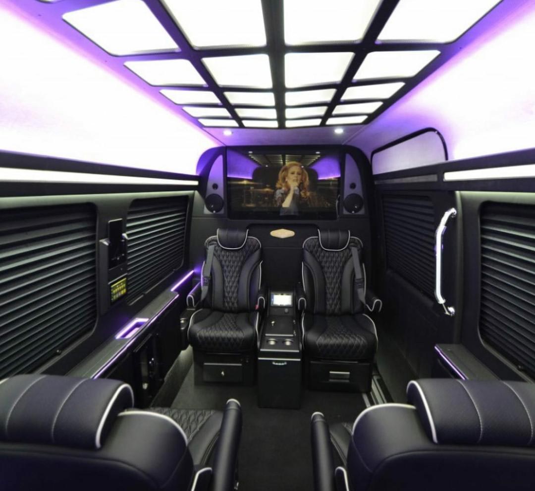 The inside of a van with purple lights and black seats