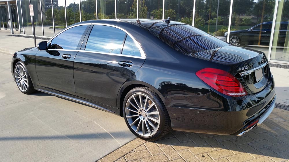 A black mercedes benz s class is parked in a parking lot.