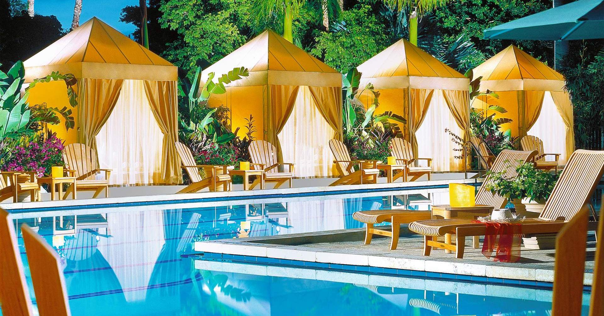 A row of tents sit next to a swimming pool