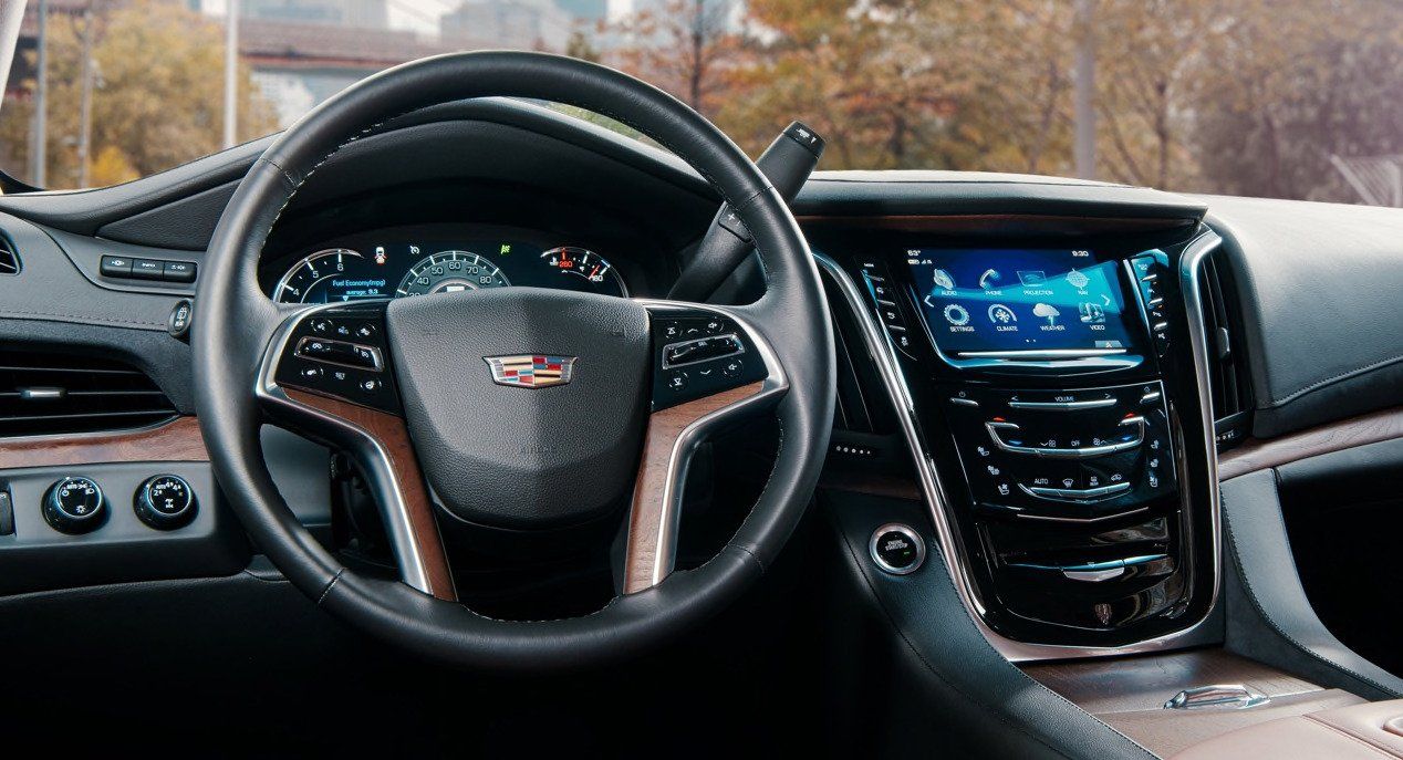 A close up of the steering wheel and dashboard of a car.