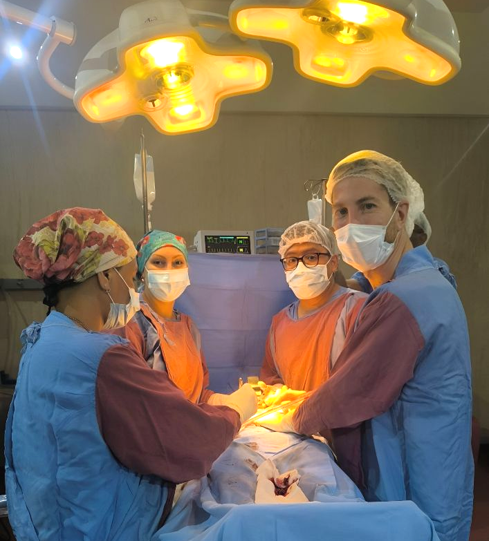Equipo médico realizando una cirugía bajo luces brillantes. Escenario de quirófano.
