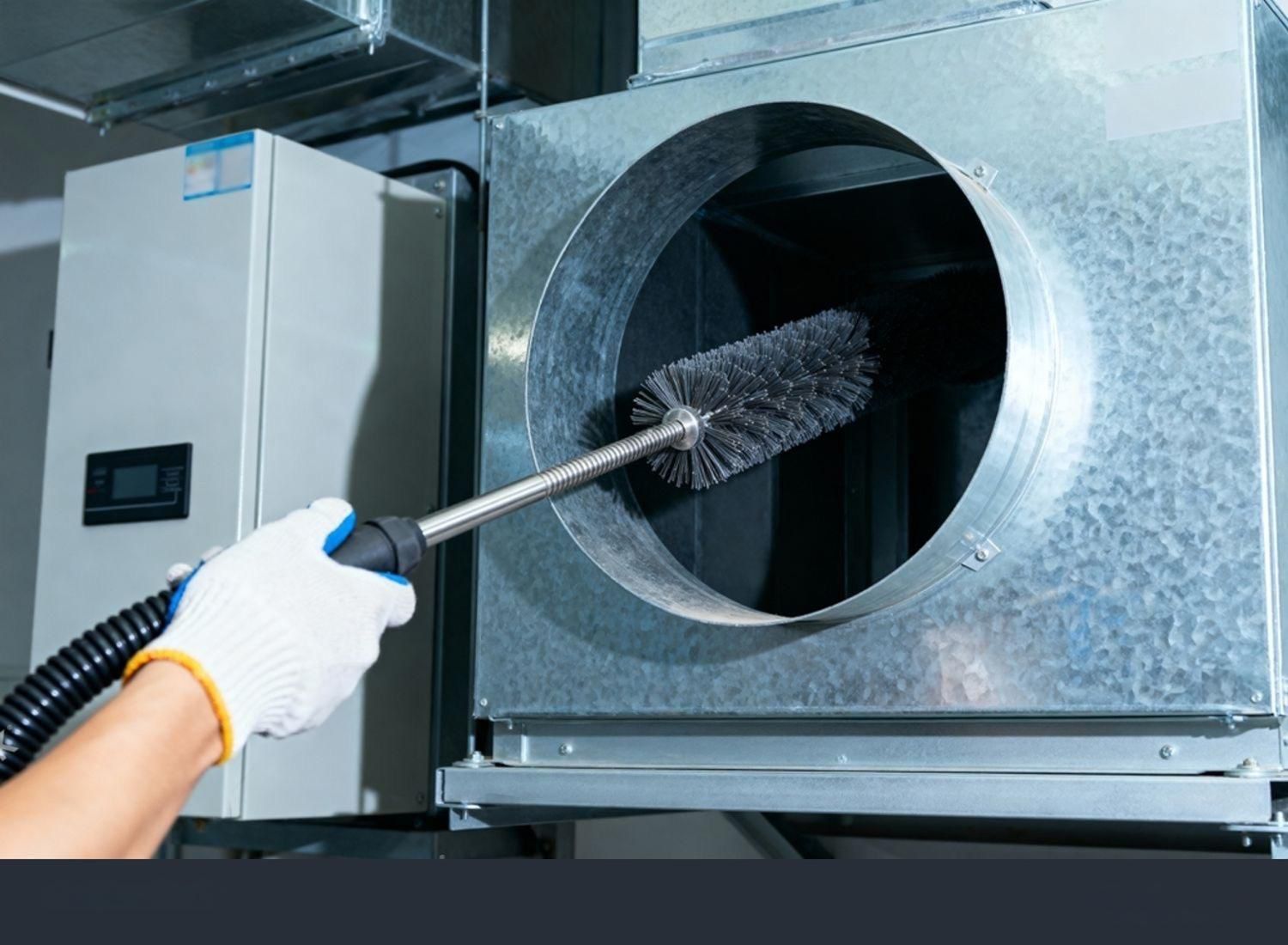 Person cleaning HVAC ductwork with a brush and vacuum.