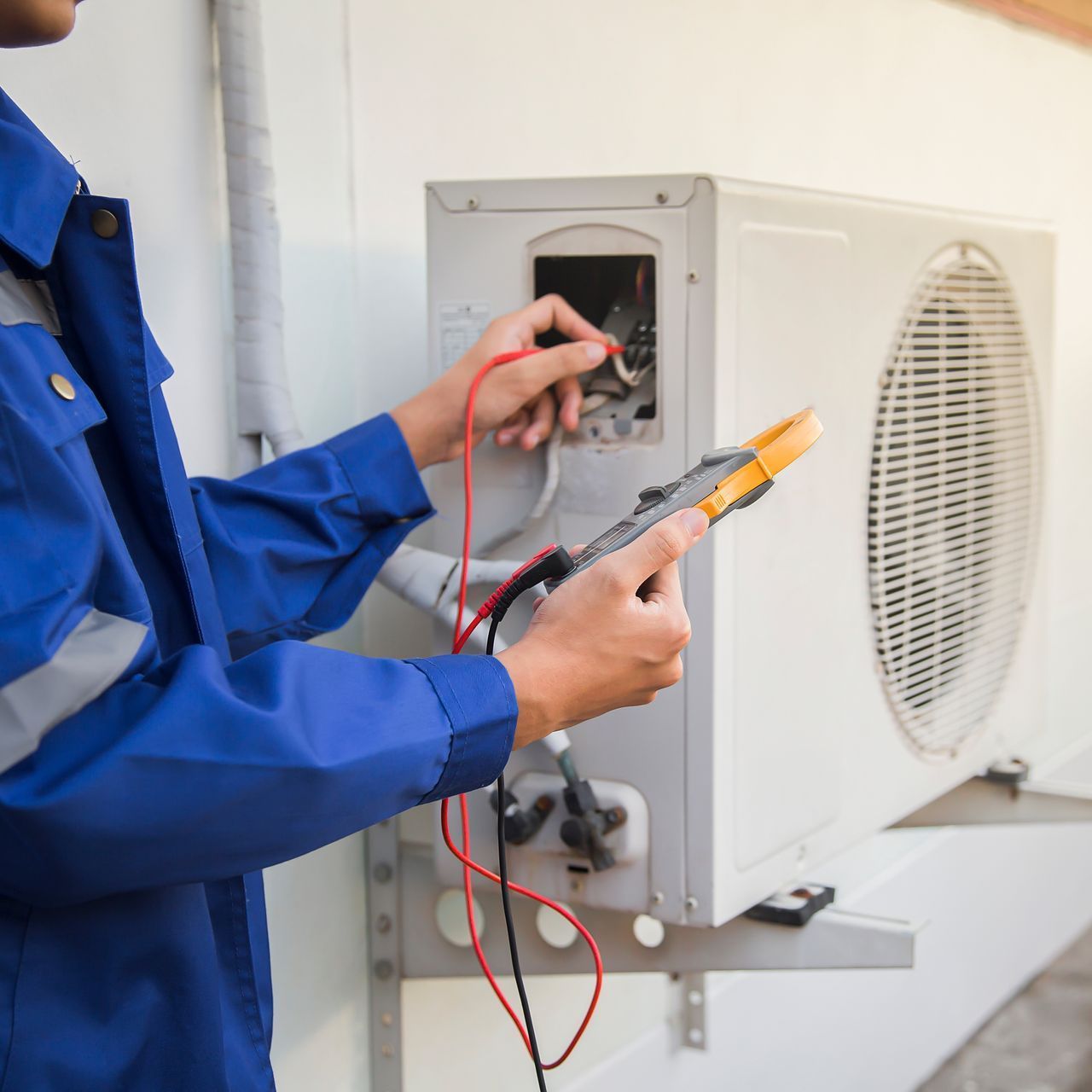 HVAC technician calibrating outdoor unit