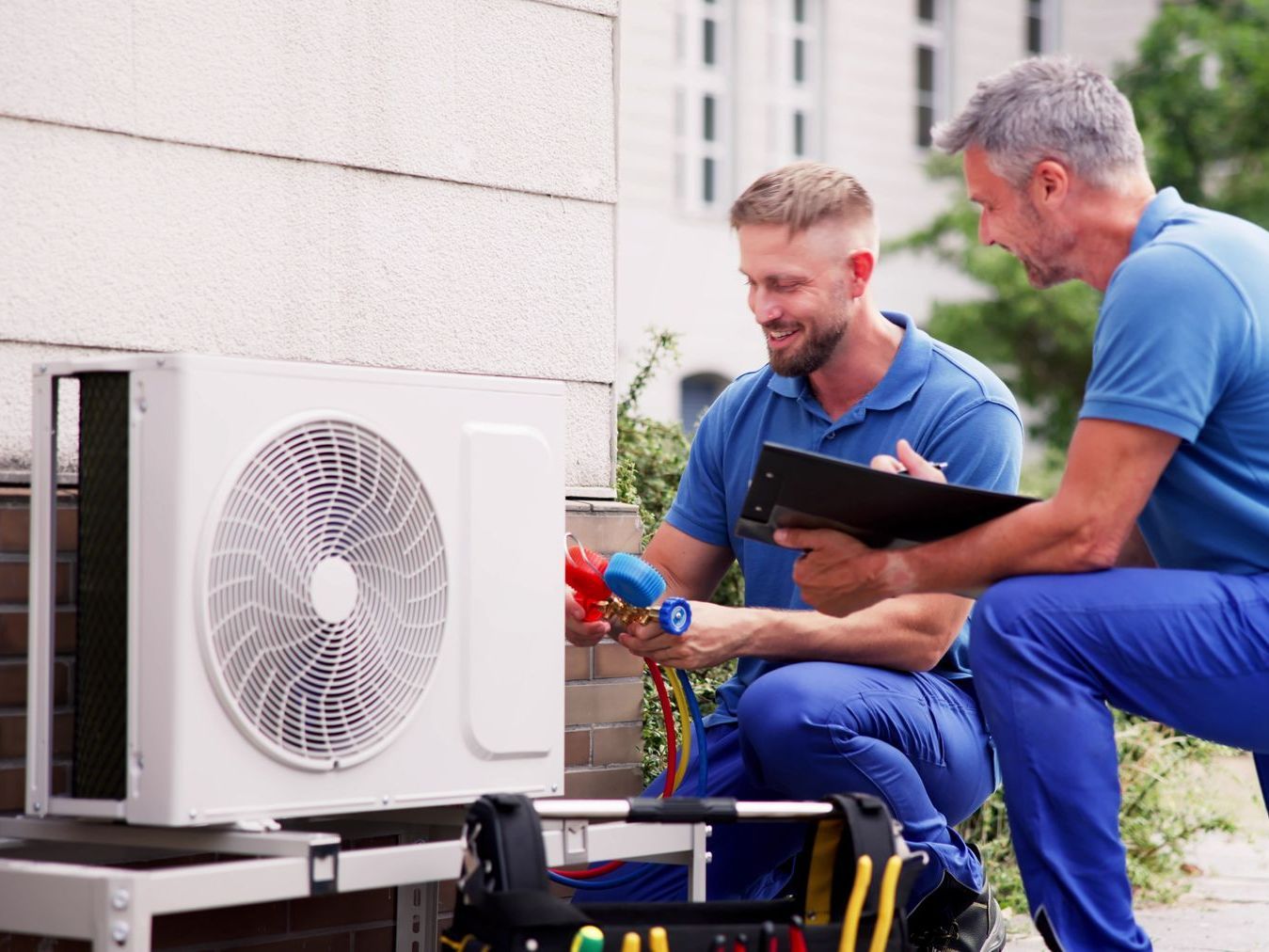HVAC technicians repairing outdoor cooling unit