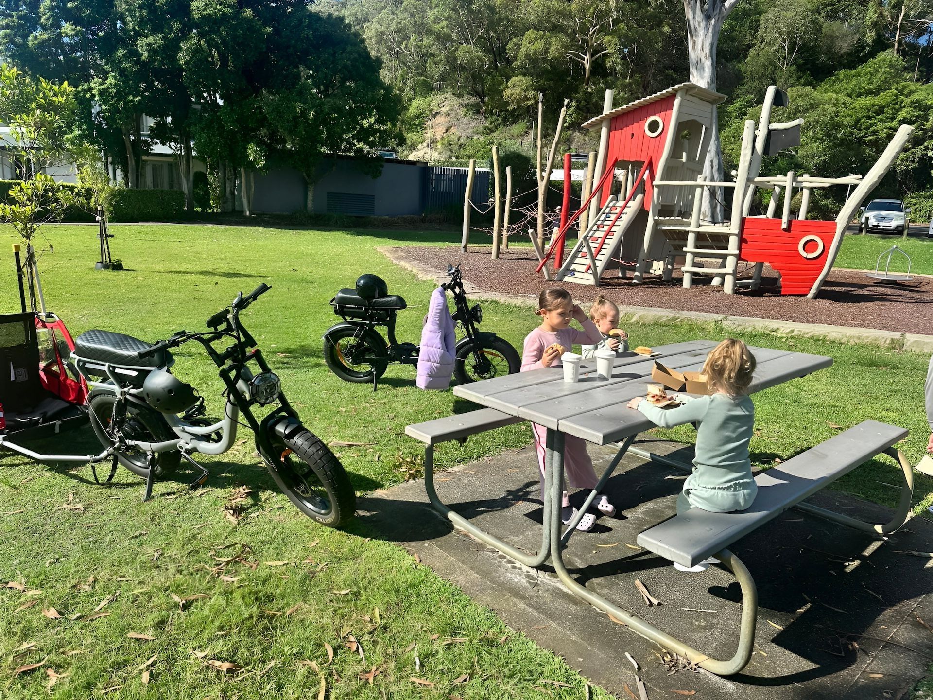 Children at Picnic Table, Ebikes and Playground in Grassy Park — E-Go-Try-Bikes in Nelson Bay, NSW