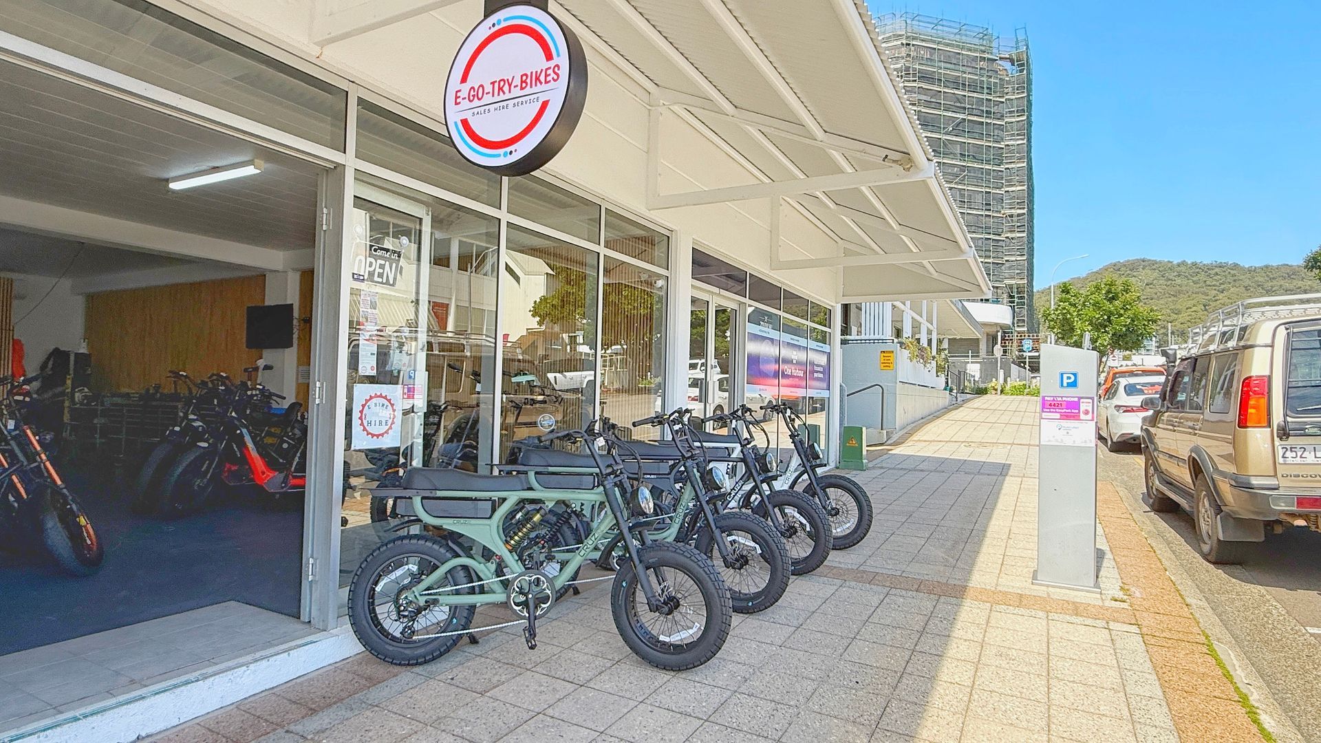 Man and Two Others Near an E-bike Outside a Shop — E-Go-Try-Bikes in Nelson Bay, NSW