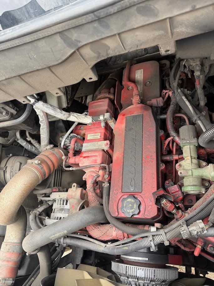 Engine compartment of a red semi-truck. Various components and wiring are visible.