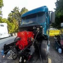 Red truck engine being worked on outdoors.