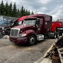 A maroon semi-truck parked outdoors.