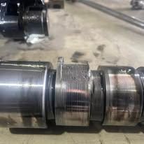 Close-up of a damaged metal part, likely from a machine, with visible wear and tear.