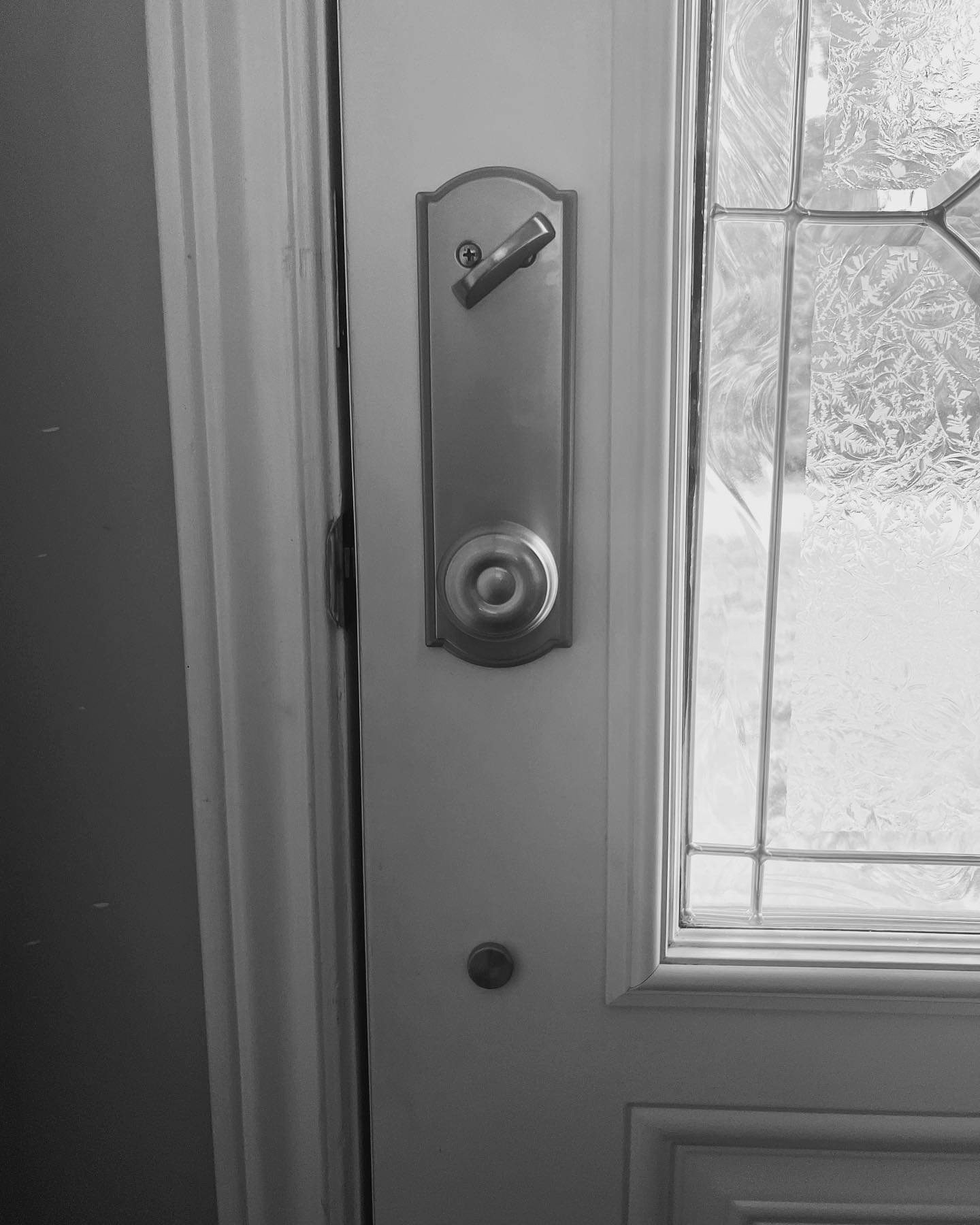 Une photo en noir et blanc d'une porte avec une clé dessus.