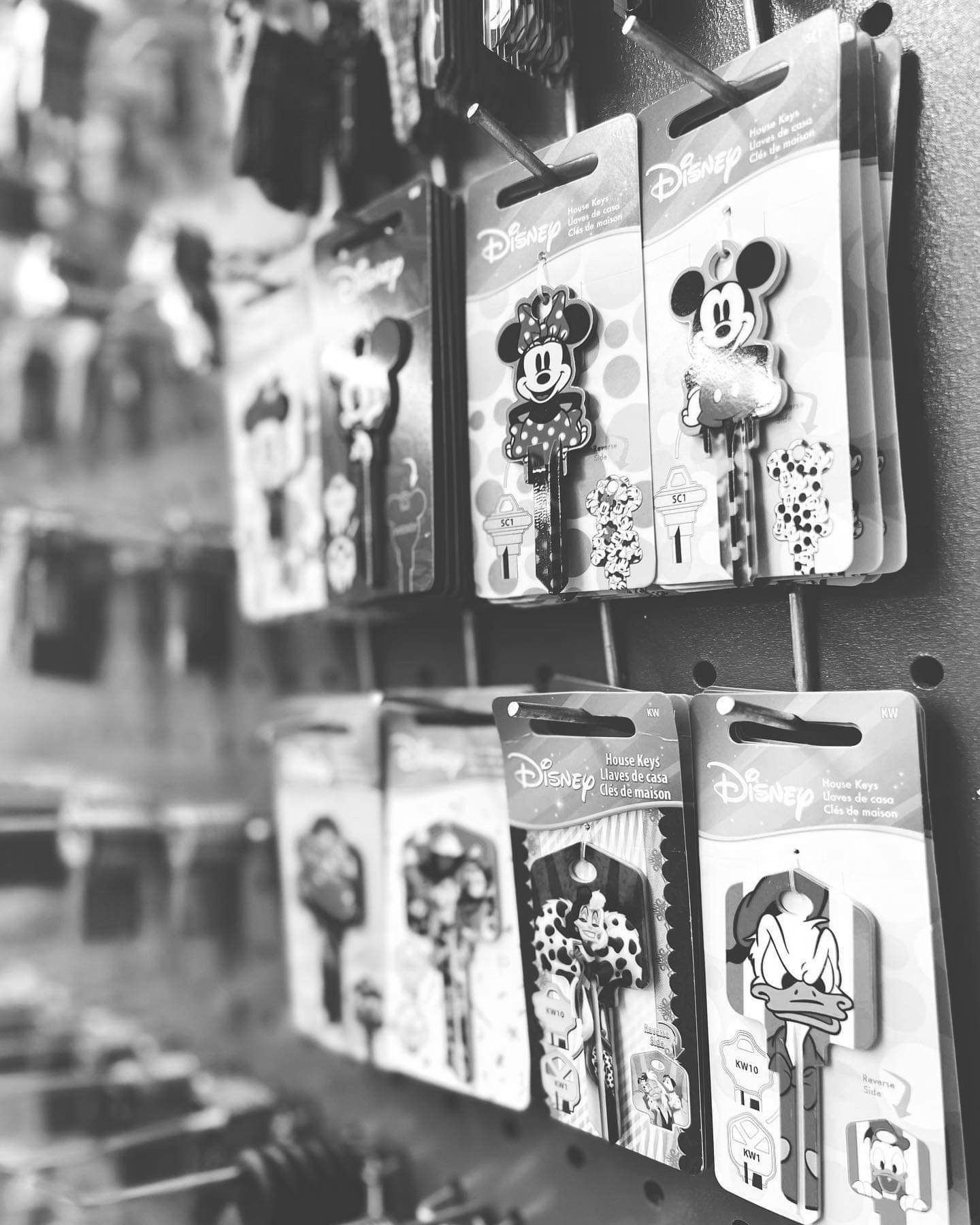 Une photo en noir et blanc de clés Disney accrochées à un mur.