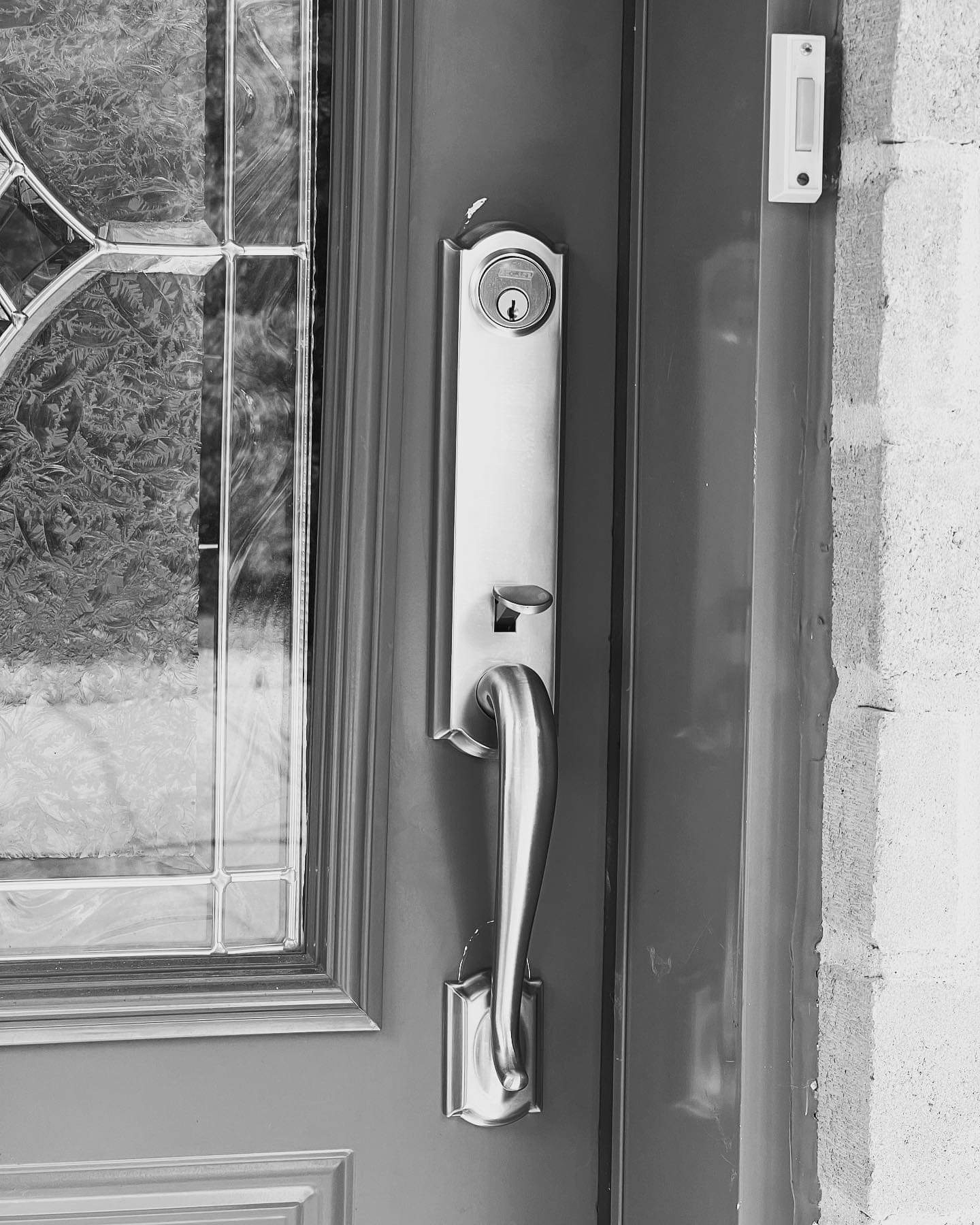 Une photo en noir et blanc d'une porte avec une poignée et une serrure