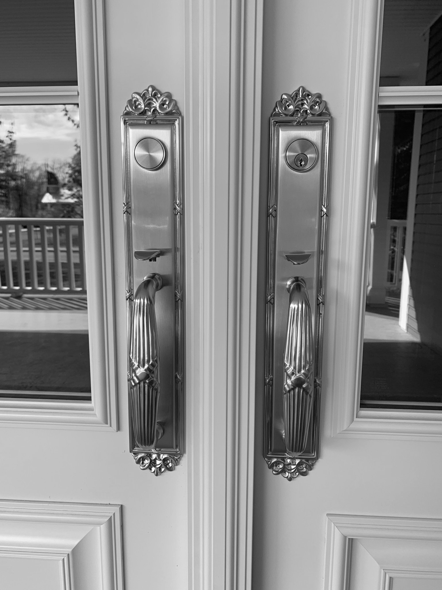 Une photo en noir et blanc d'une porte avec des poignées chromées