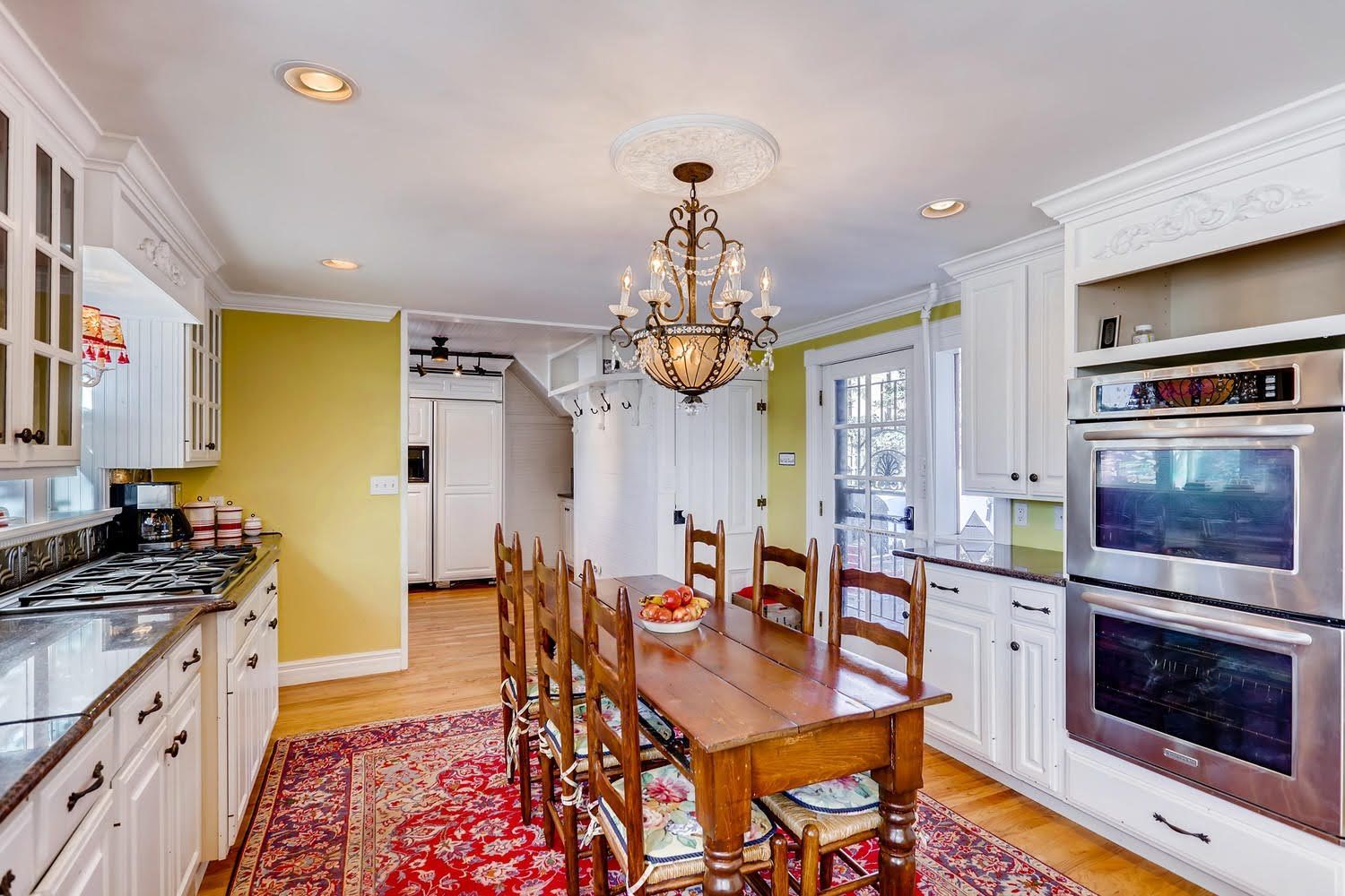 A kitchen with a table and chairs and a chandelier