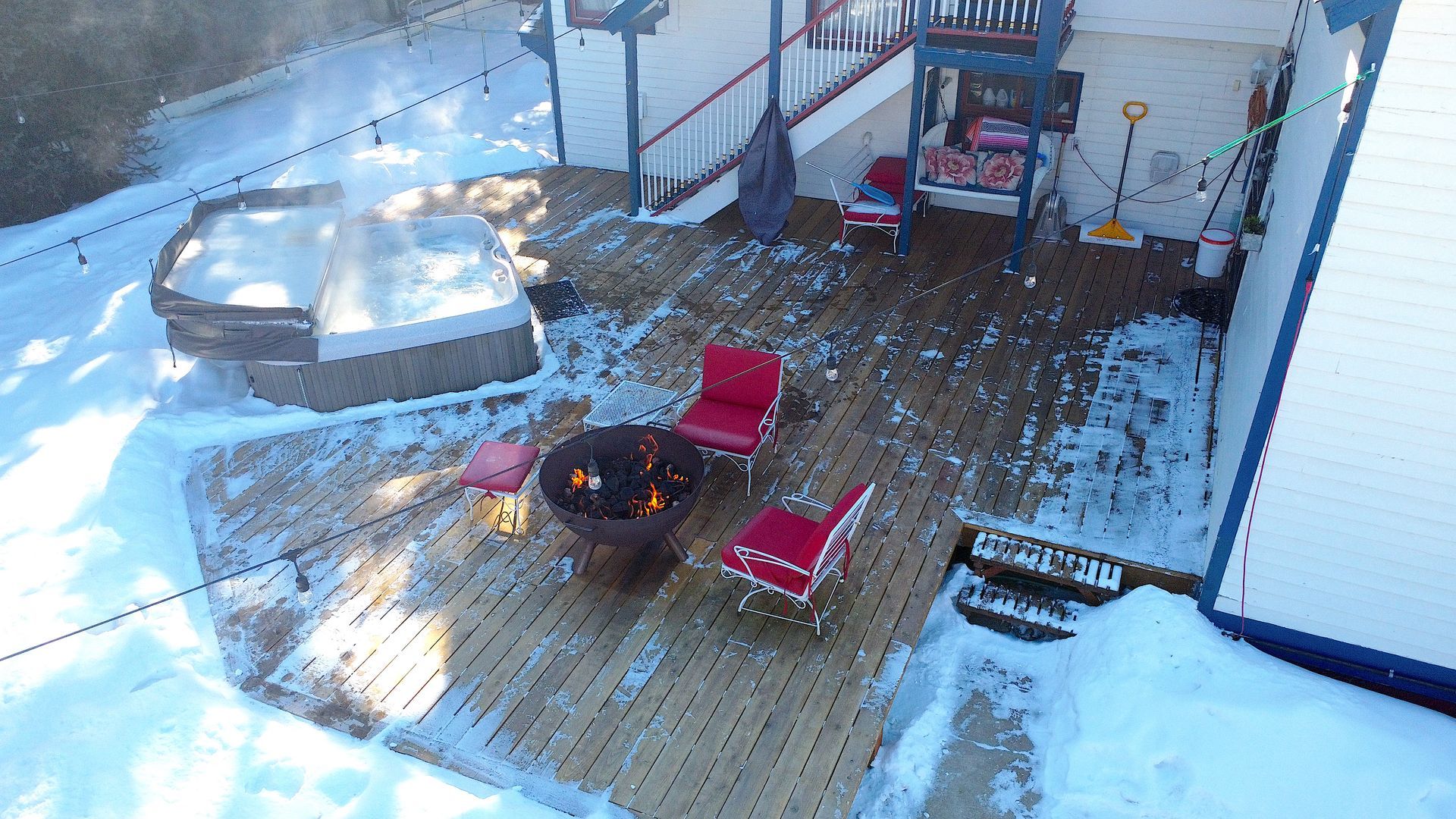An aerial view of a deck with a hot tub and a fire pit