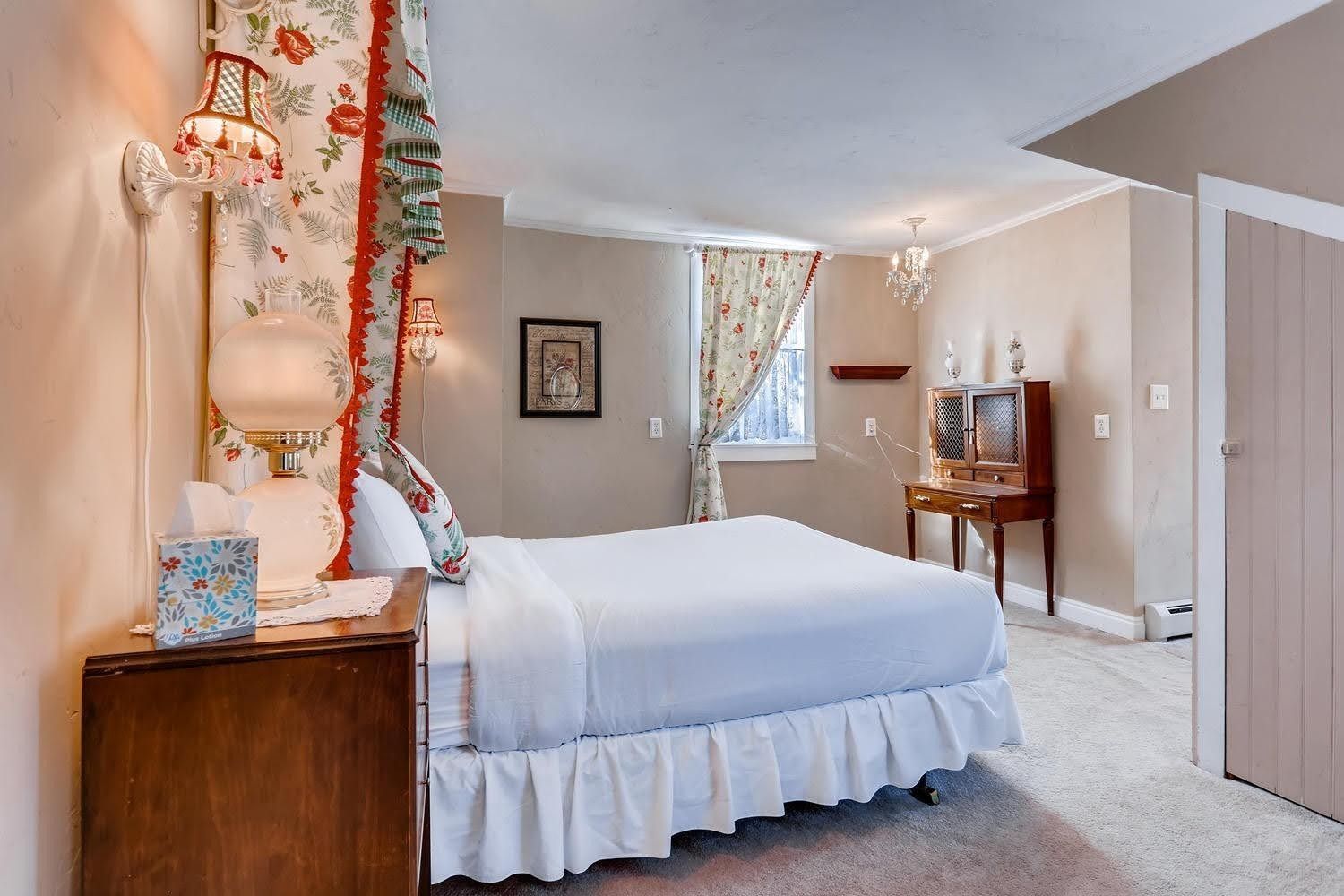 A bedroom with a canopy bed and a nightstand.