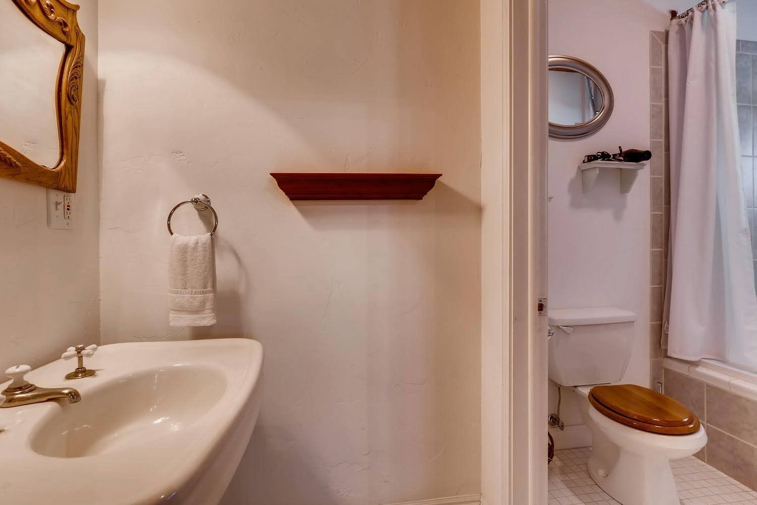 A bathroom with a sink , toilet and mirror.