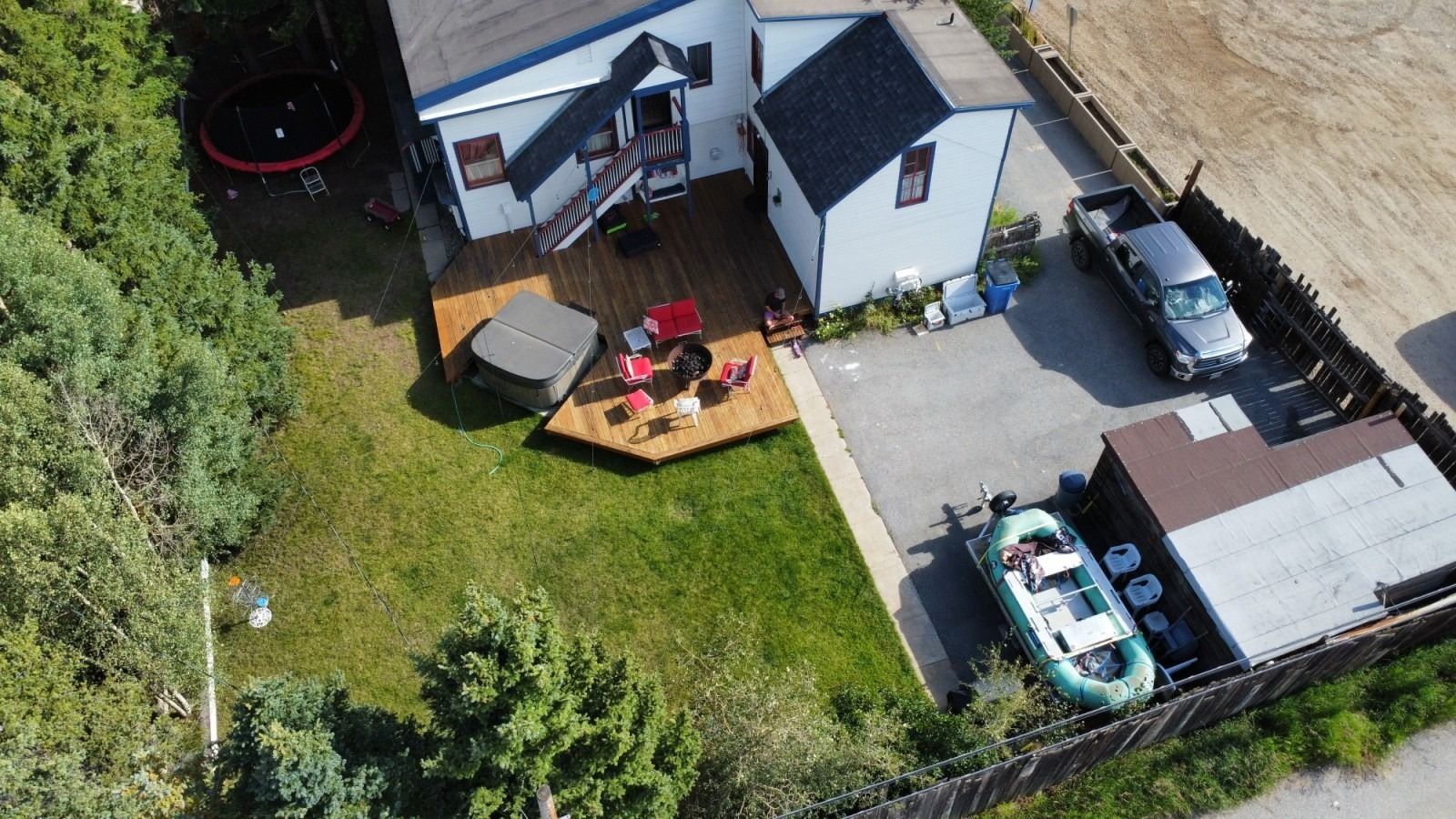 An aerial view of a house with a boat in front of it.
