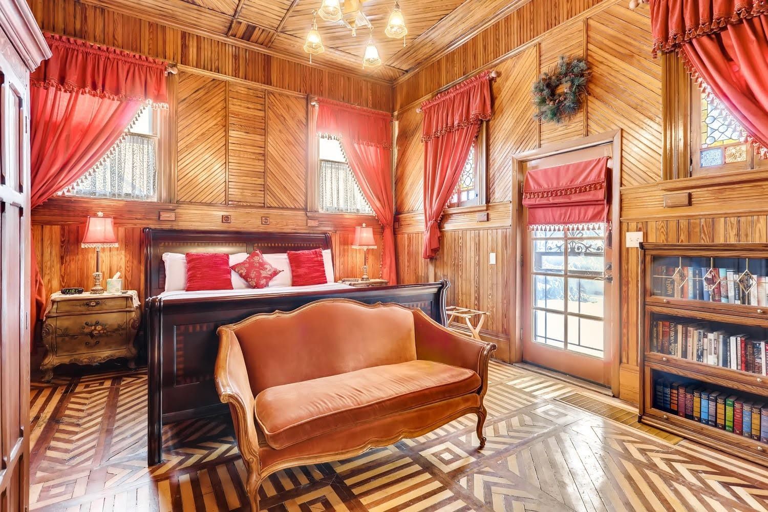 A bedroom with a bed , couch , and bookshelf.