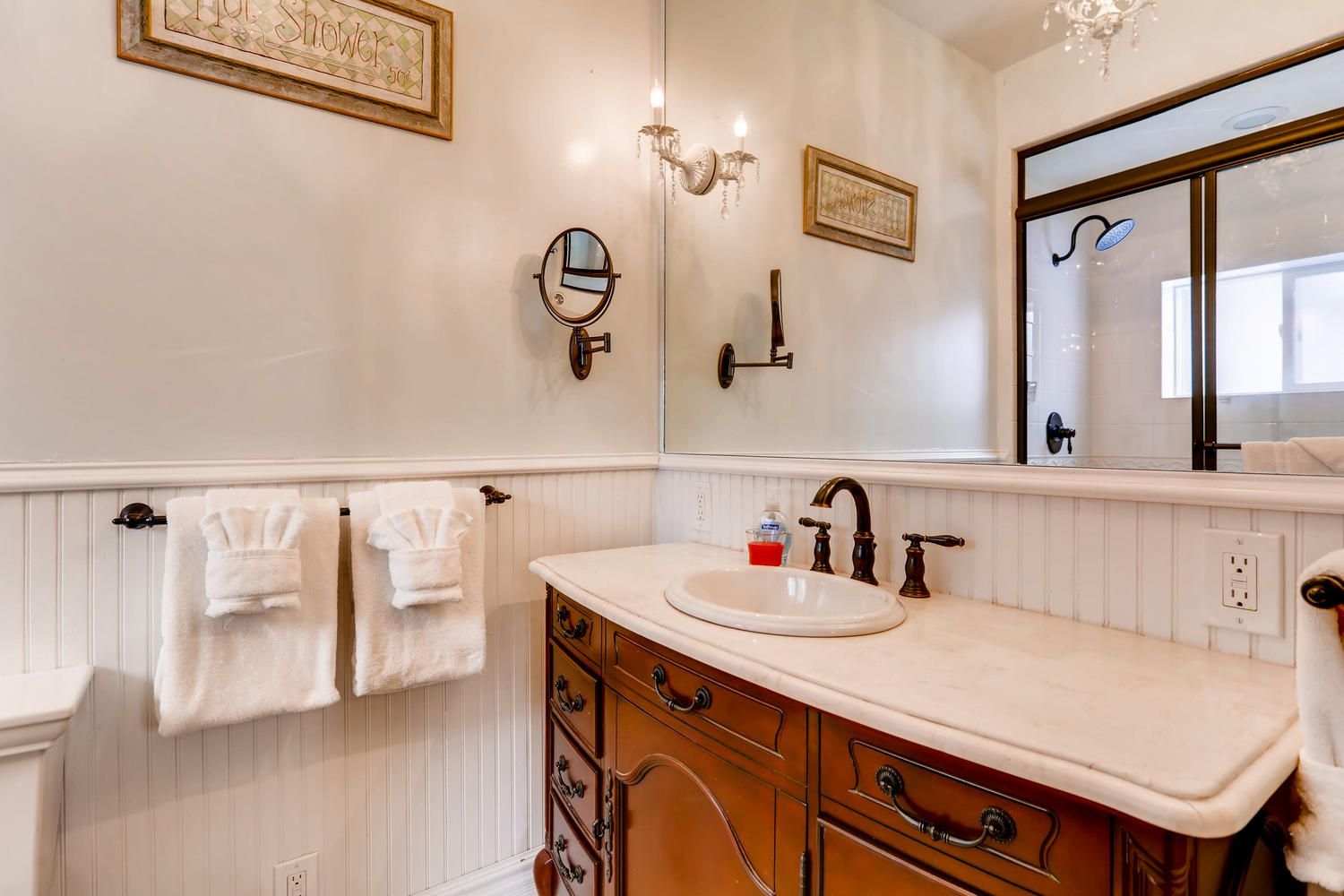 A bathroom with a sink , mirror and towels on the counter.