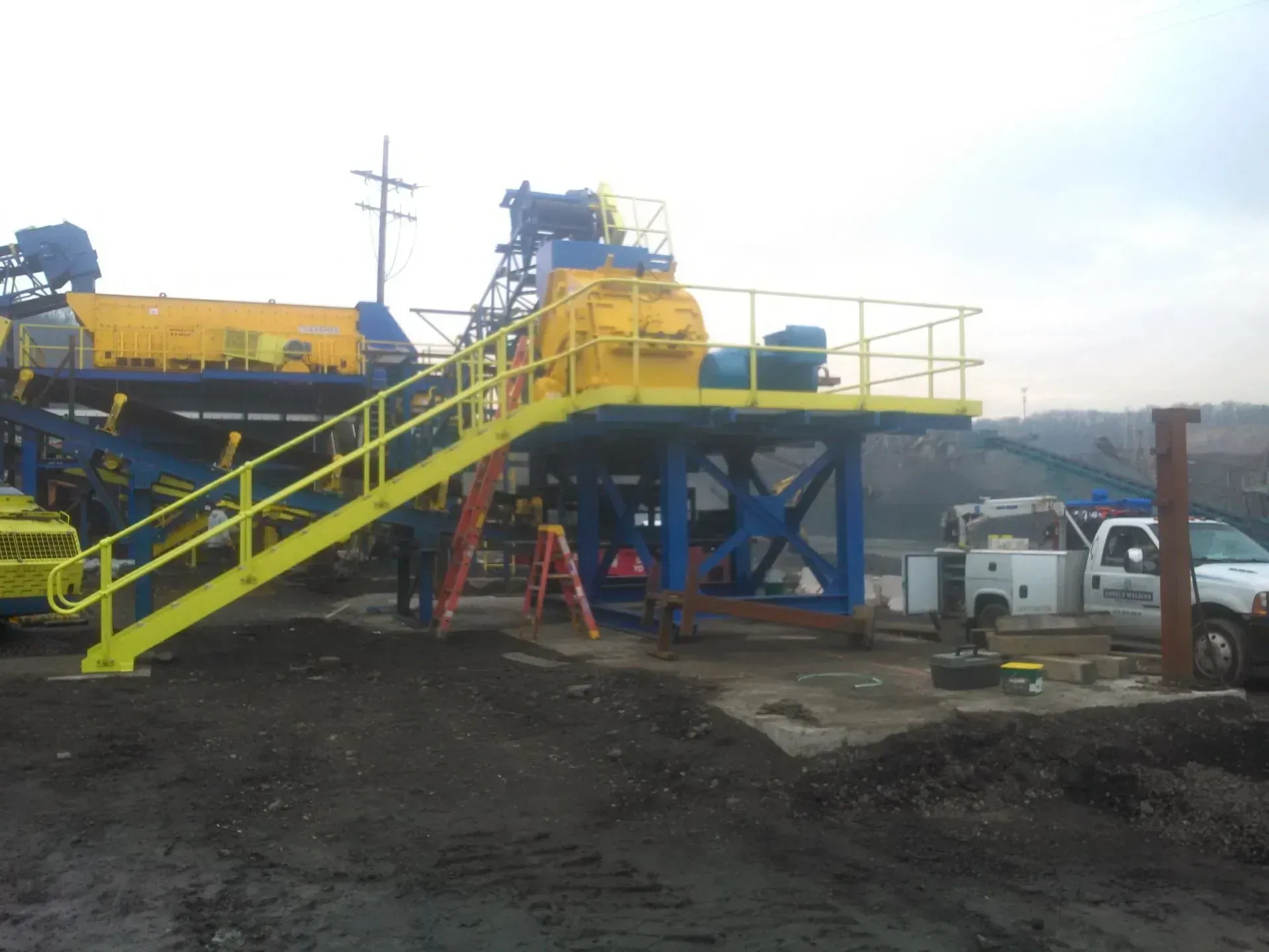 A yellow and blue machine with stairs leading up to it.
