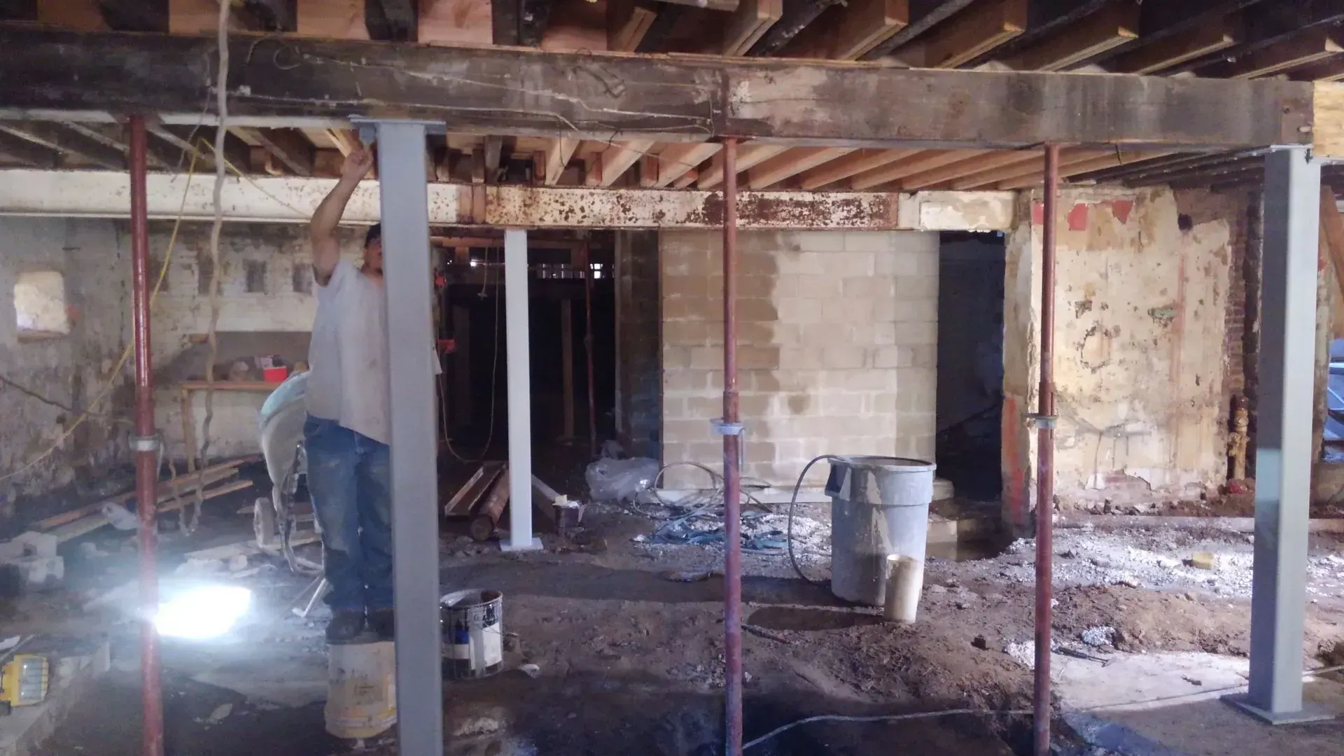 A man is standing in a basement under construction.