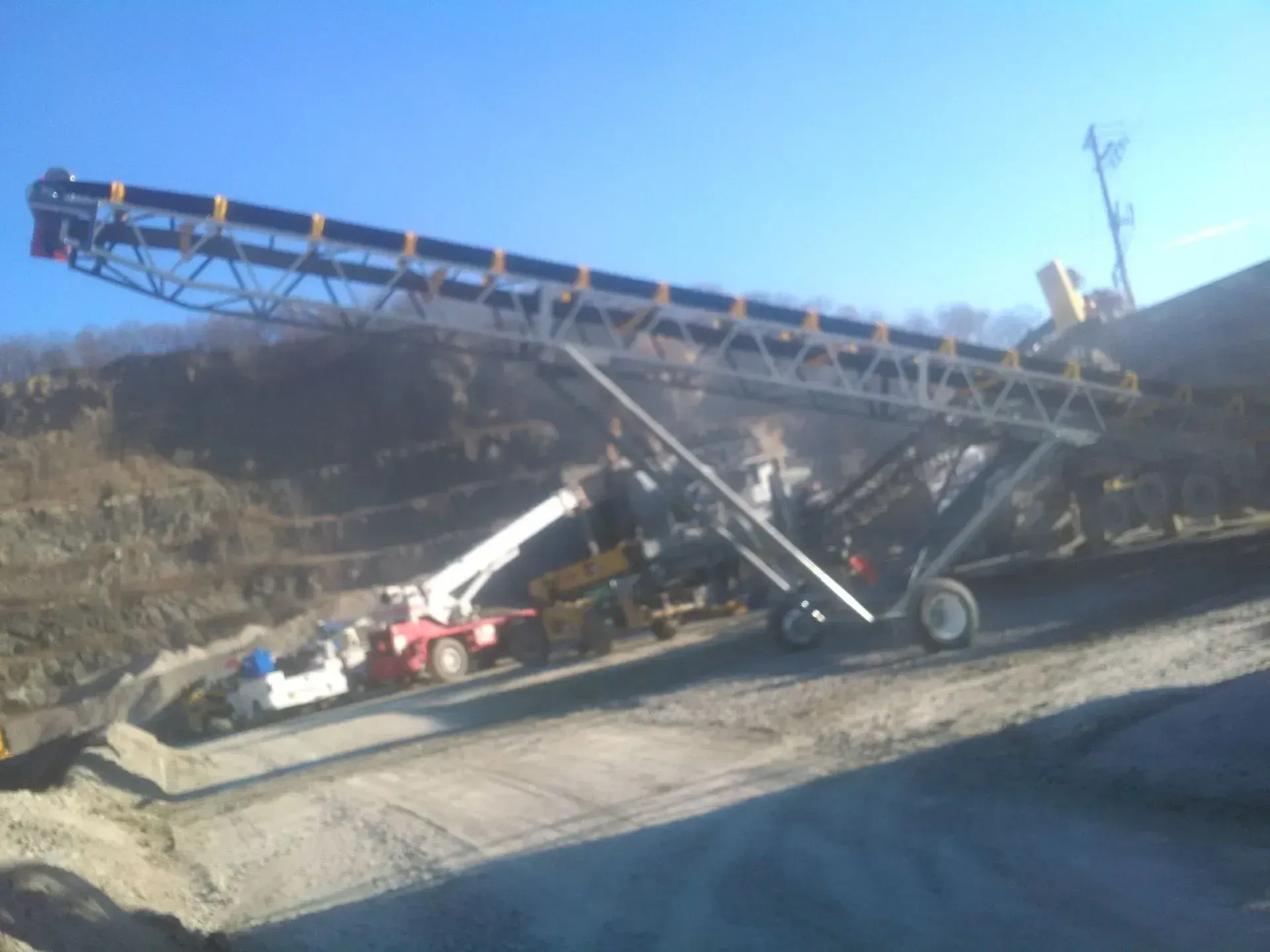 A conveyor belt is going down a dirt road.