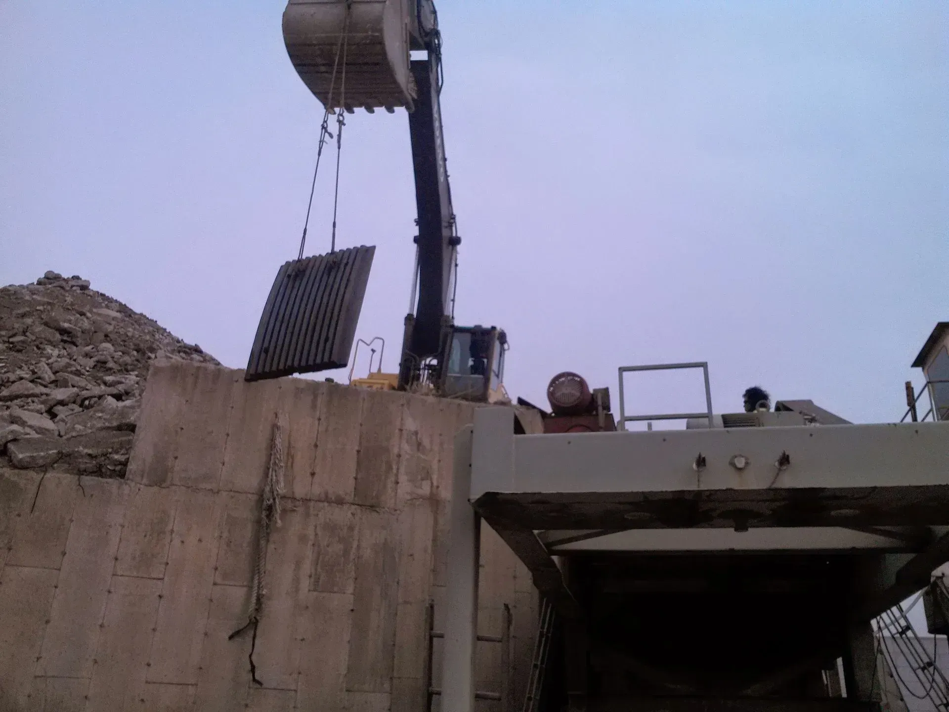 A crane is lifting a piece of metal into the air.