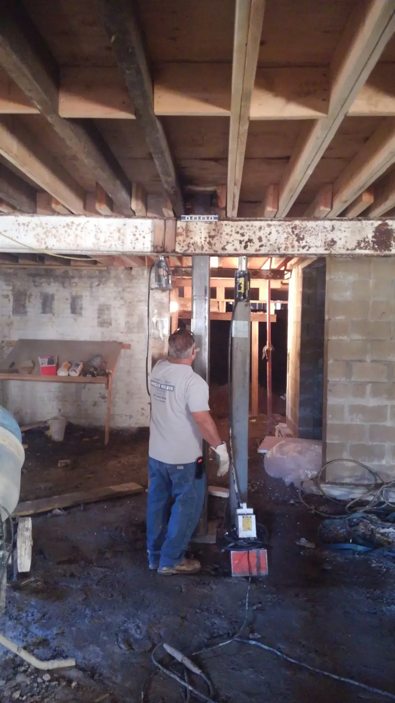 A man is standing in a basement under construction.