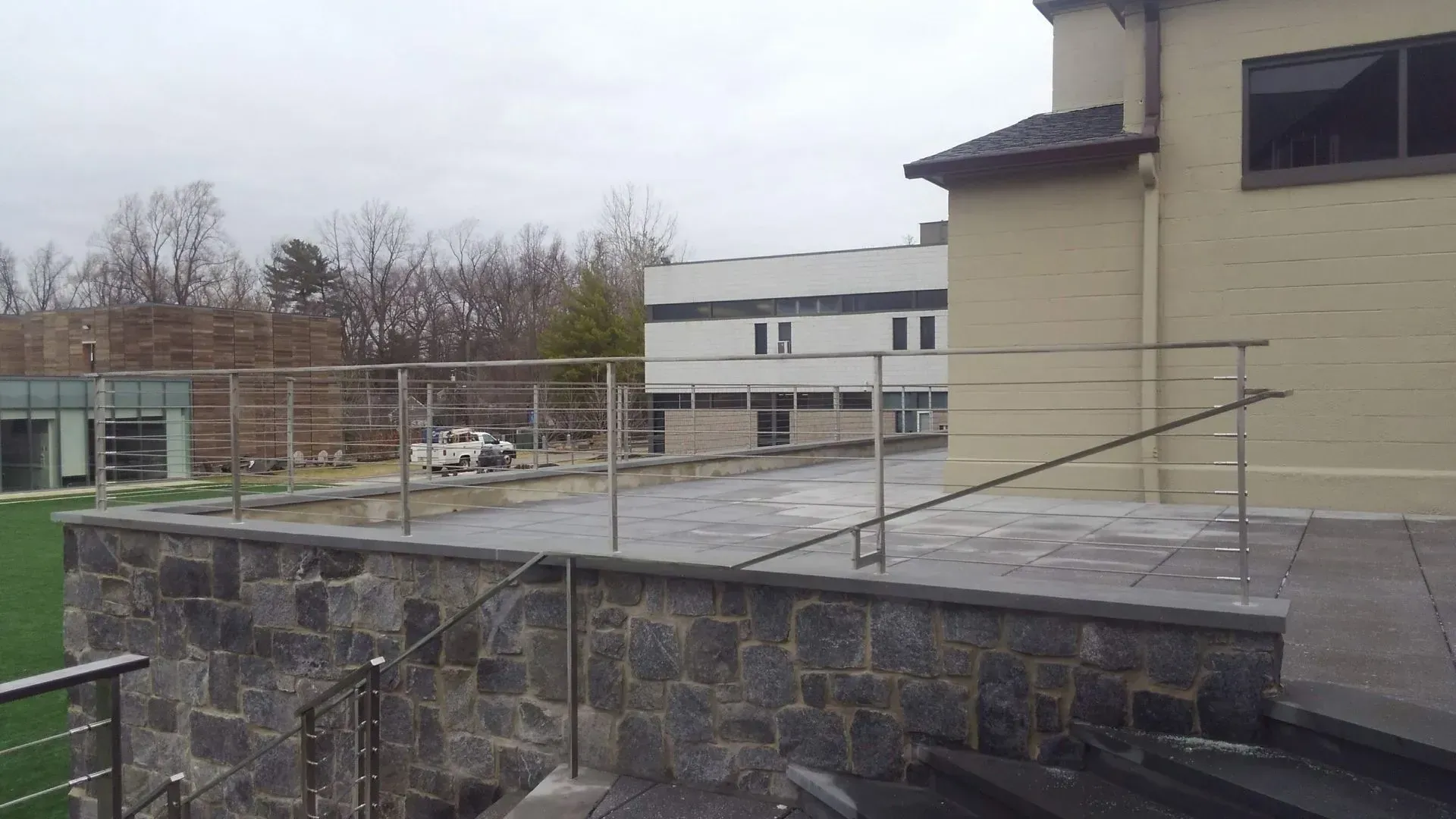 A building with a stone wall and a stainless steel railing.