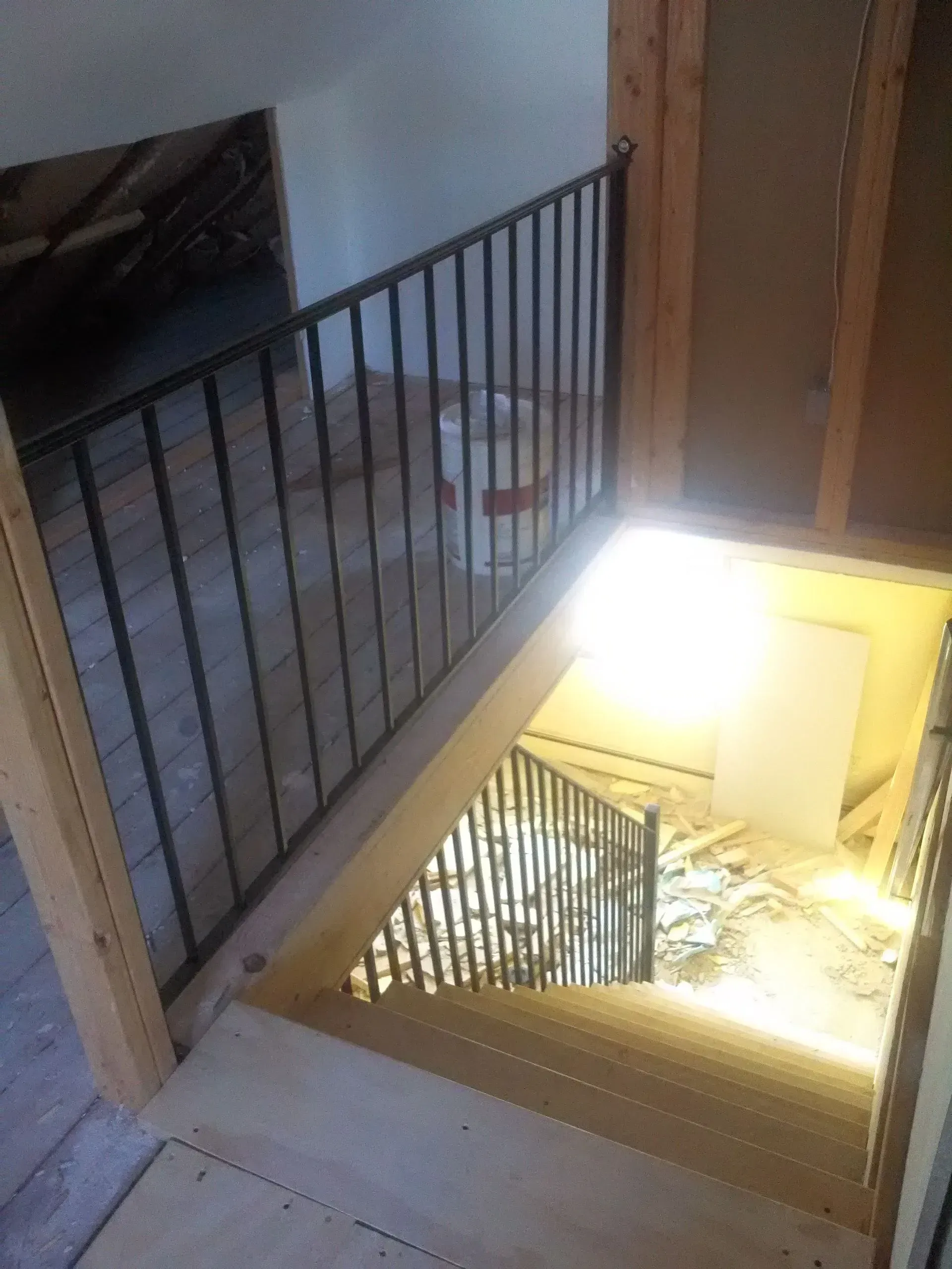A staircase with a metal railing and a light shining through it.