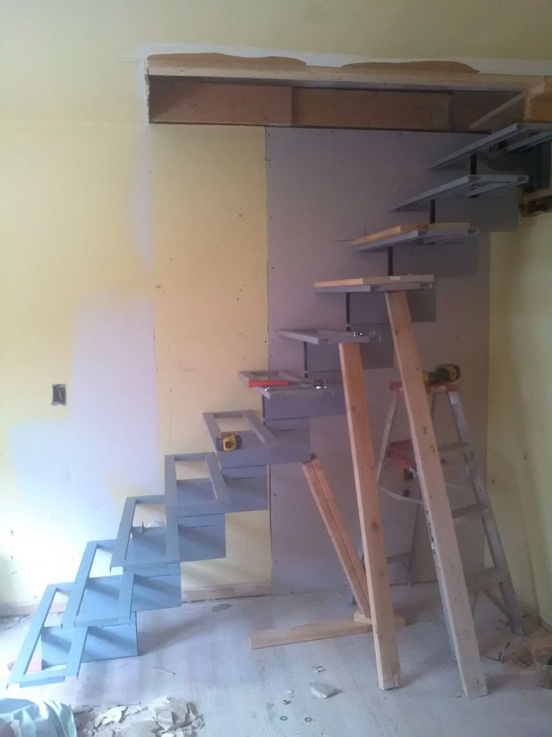 A staircase is being built in a room with a wooden ladder.