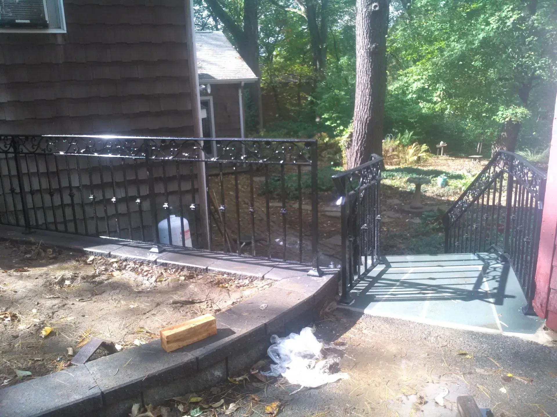 A house with a fence and stairs in front of it.