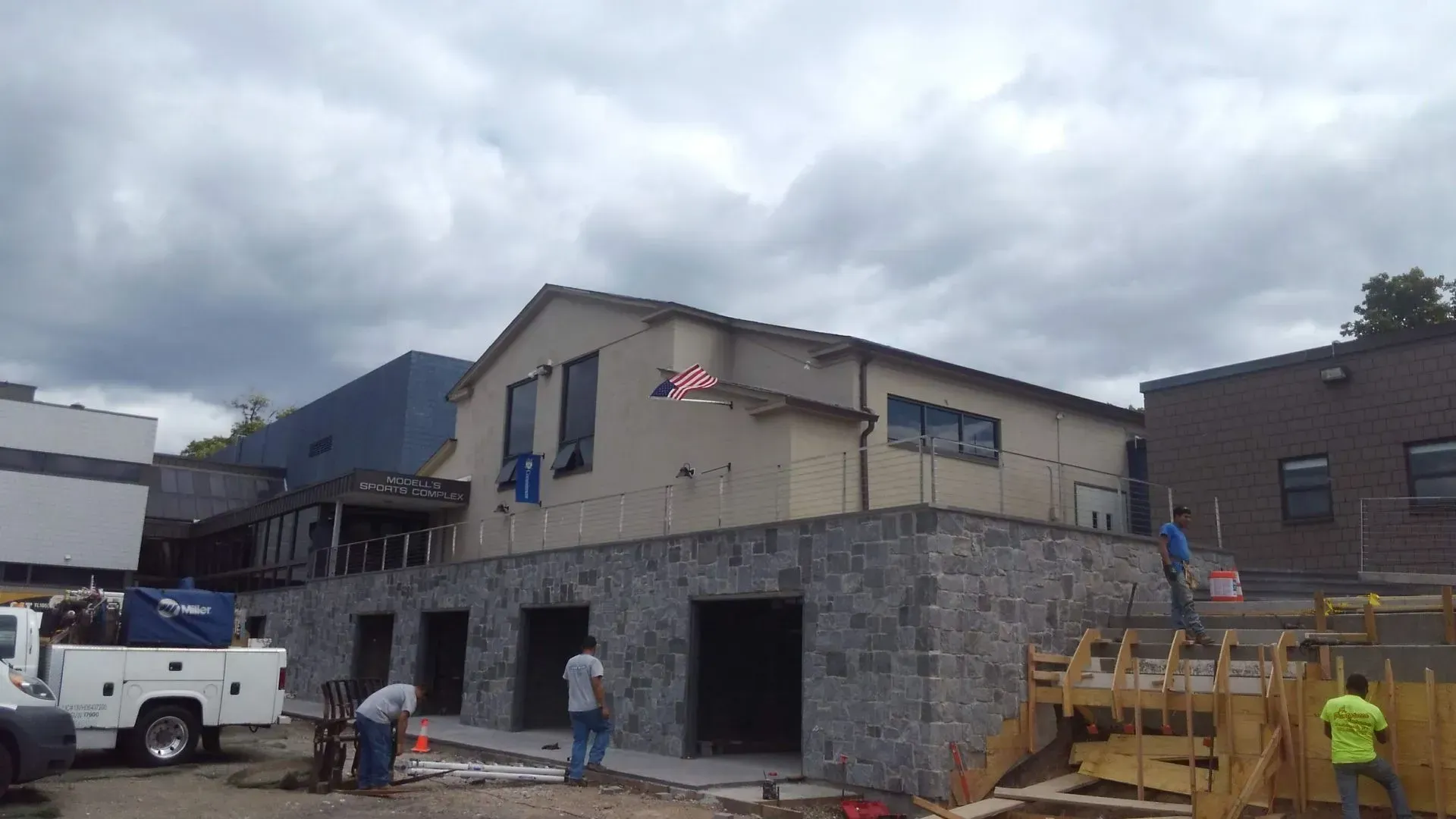 A white truck is parked in front of a building under construction.